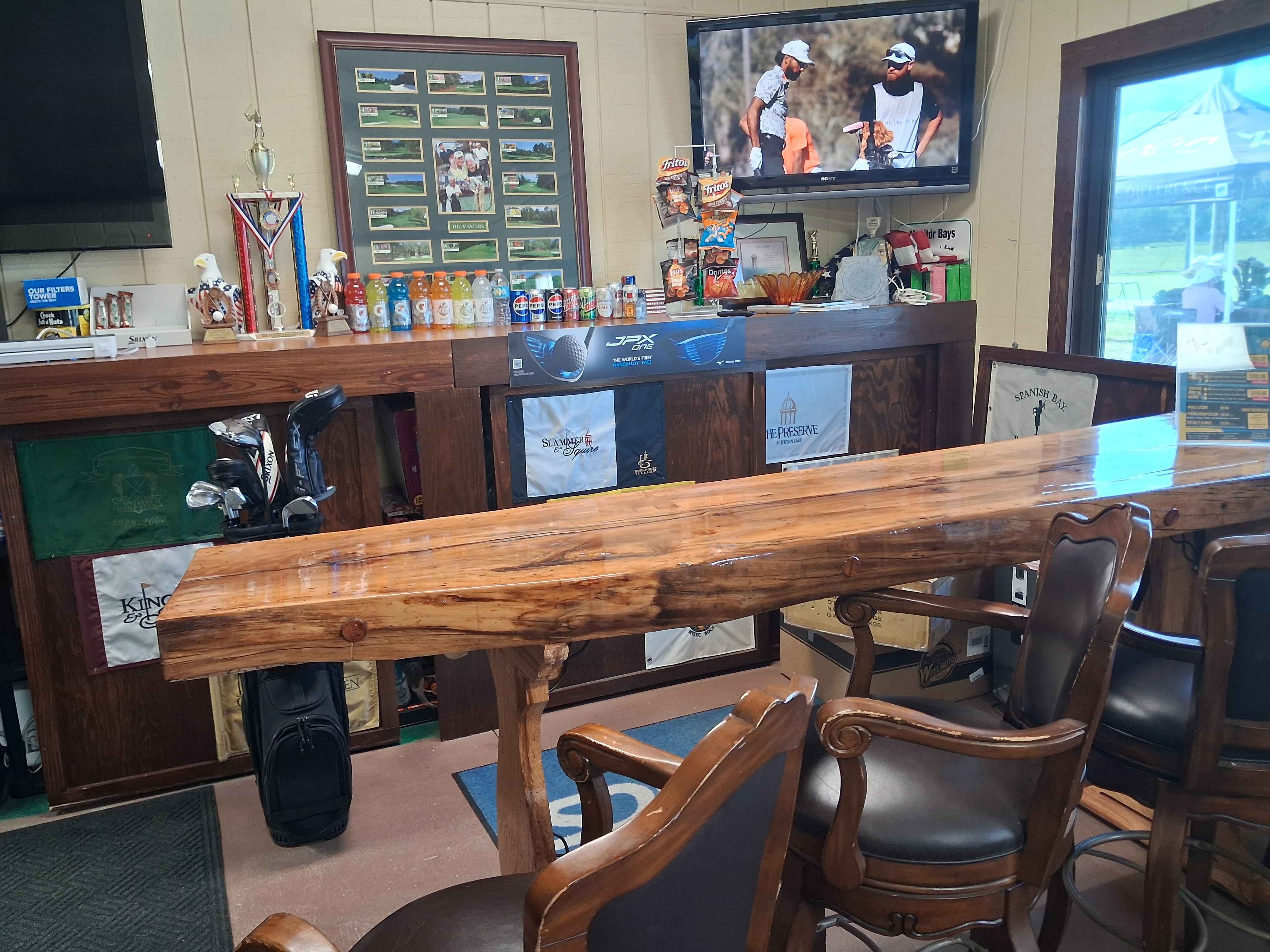 Oxford Golf Academy pro shop lounge area with trophies and golf course flags